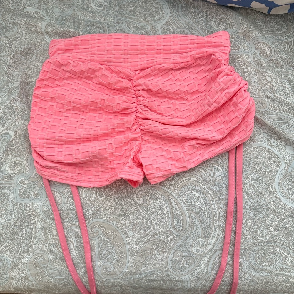 Pink textured butt scrunch spandex shorts with strings on the side to tighten